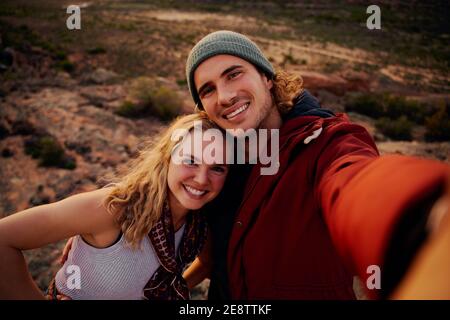 Portrait d'un jeune couple de randonnée heureux prenant selfie de haut de la montagne Banque D'Images