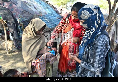 Beawar, Rajasthan, Inde, 01 février 2021 : un agent de santé Anganwadi administre des gouttes de polio à un nouveau-né dans un bidonville pendant le programme d'éradication de Pulse Polio à Beawar. Crédit : Sumit Saraswat/Alay Live News Banque D'Images