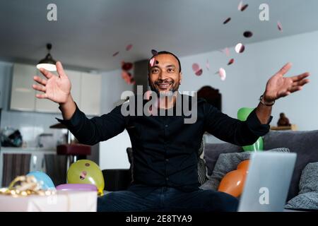 Joyeux homme de 40 ans qui jette des confetti à la maison Banque D'Images