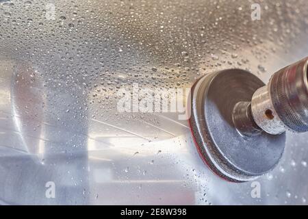 Image détaillée d'un outil de polissage pour le polissage des phares de voiture pour les restaurer. Gouttes d'eau sur le phare de voiture. Banque D'Images