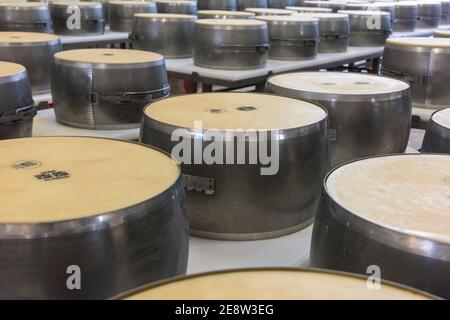 Parmigiano reggiano fromage dans des moules en métal pour le façonner en les tours sont prêts à être stockés et à mûrir dans Bologne Italie Banque D'Images