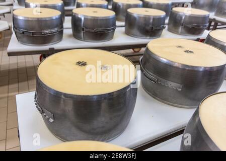 Parmigiano reggiano fromage dans des moules en métal pour le façonner en les tours sont prêts à être stockés et à mûrir dans Bologne Italie Banque D'Images