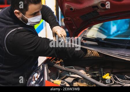 mécanicien répare la voiture . Concentrez-vous sur les mains. COVID 19 Banque D'Images