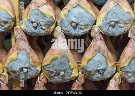 Les jambes de jambon de parme mûrissement dans une usine alimentaire à Bologne Italie Banque D'Images