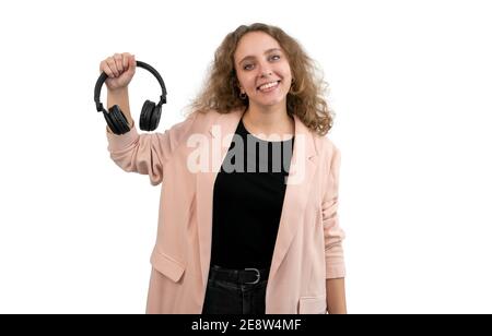 Une femme d'affaires en costume tient un casque avec sa main, isolée sur fond blanc. La femme a des cheveux blonds bouclés. Banque D'Images