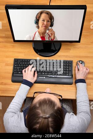 Image symbolique de la télémédecine, le patient parle à un médecin lors d'une vidéoconférence, de chez lui, Banque D'Images