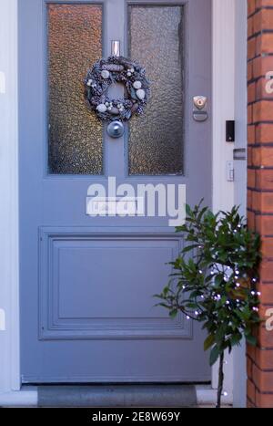 Belle maison de porte avant grise bleue avec décoration de couronne de Noël. Style anglais maison. Image verticale. Banque D'Images
