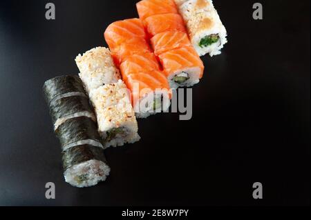 Petits pains à sushis servis sur fond sombre Banque D'Images
