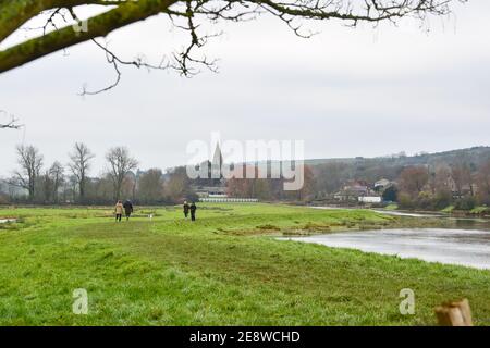 Brighton Royaume-Uni 1er février 2021 - marcheurs pour chiens au bord de la rivière Cuckmere à Alfriston près de Seaford dans East Sussex par une journée sombre et nuageux dans le Sud-est . Les niveaux d'eau de la rivière sont élevés avec les champs environnants étant inondés après des semaines de pluie durables à travers les mois d'hiver en Grande-Bretagne : crédit Simon Dack / Alamy Live News Banque D'Images