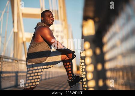 Portrait du jeune homme afro-américain en vêtements de sport qui s'exerce pour réduire son poids corporel. Banque D'Images