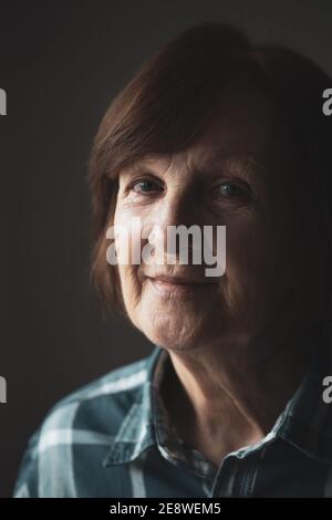 Portrait d'une femme âgée dépressive qui regarde malheureusement l'appareil photo. Banque D'Images