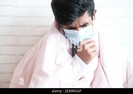 un jeune homme malade tousse et éternue Banque D'Images