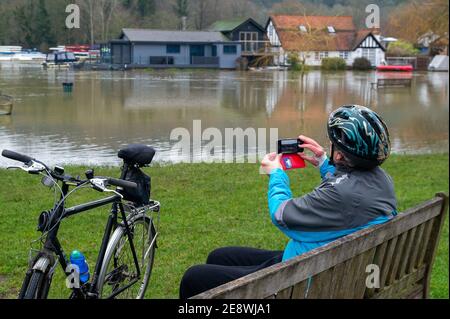 Henley-on-Thames, Oxfordshire, Royaume-Uni. 1er février 2021. Un cycliste s'arrête pour prendre une photo de l'inondation. Un avertissement d'inondation est en place pour la Tamise à Henley. On s'attend à ce que les inondations se poursuivent aujourd'hui et on a demandé aux personnes vivant près de la Tamise d'activer leurs barrières d'inondation. De nombreux champs utilisés pour la célèbre régate royale de Henley sont maintenant sous l'eau. Crédit : Maureen McLean/Alay Live News Banque D'Images