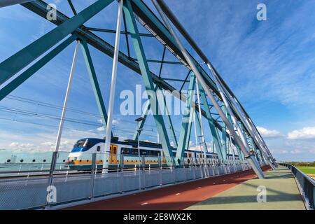 Train de voyageurs néerlandais passant par un pont à Nimègue, dans le Gelderland Banque D'Images