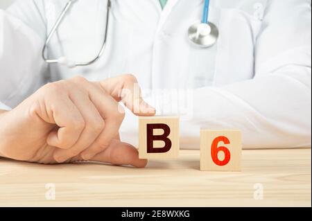le médecin recommande de prendre de la vitamine b12. le médecin parle des avantages de la vitamine b6. Vitamine - concept de santé. Alphabet B6 sur cube en bois. Tient la main a Banque D'Images