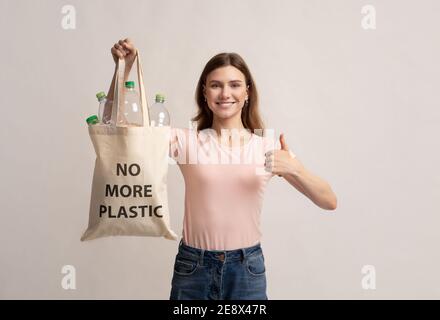 Femme tenant un sac Eco avec des bouteilles vides et pas plus Inscription en plastique Banque D'Images