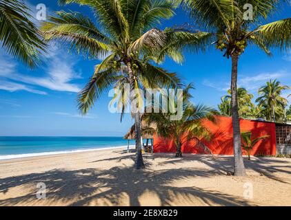 Maison rouge sur la plage donnant sur l'eau azur de Lo de Marcos sur la côte Pacifique de Nayarit, Mexique. Banque D'Images