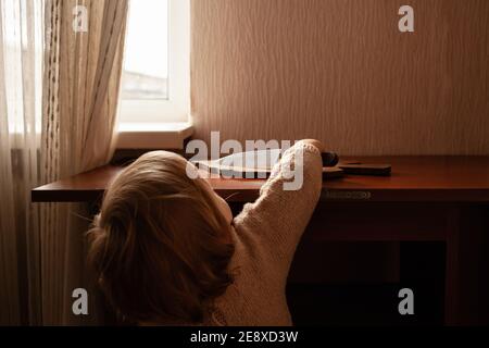 L'enfant tire un couteau de la table, danger. L'enfant peut couper, les dangers à la maison des enfants. Une petite fille d'un an avec un couteau. Banque D'Images