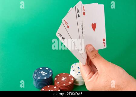 Pile de jetons et main avec quatre as, chiffon de poker, un jeu de cartes, main de poker et jetons. Arrière-plan. Banque D'Images