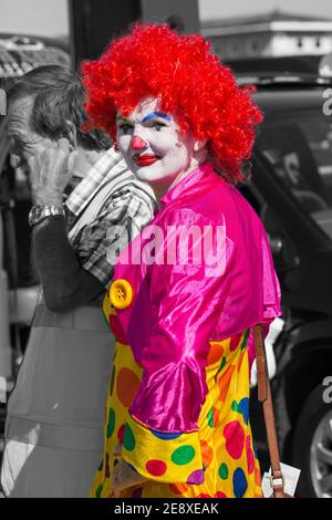 Femme habillée de clown coloré participe au carnaval de Weymouth à Weymouth, Dorset UK en août - coloration sélective de couleur, couleur pop Banque D'Images