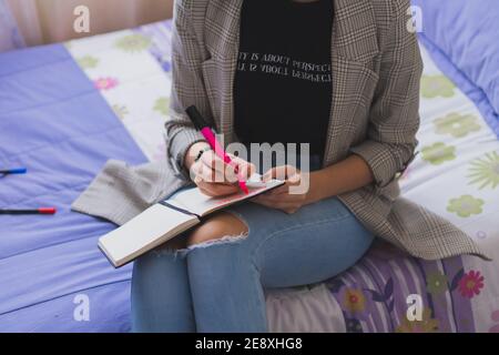 Une jeune femme écrit dans son journal. Vos pensées et idées. Banque D'Images