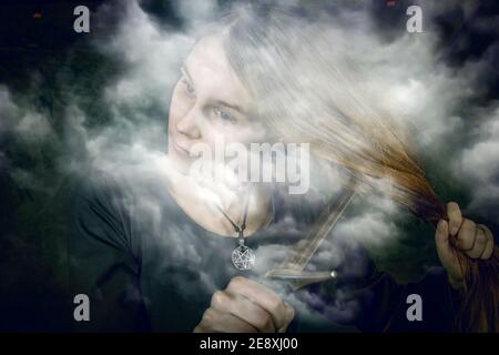 Portrait de jeune femme aux cheveux longs portant un costume médiéval. article posent avec une épée à ses cheveux sombres au fond studio Banque D'Images