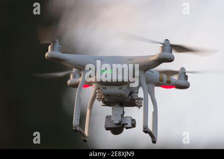 Great Malvern, Royaume-Uni, 27 décembre 2020: Le quadcopter de drone planant devant les arbres et le ciel bleu, la mise au point sélective estompe l'arrière-plan Banque D'Images