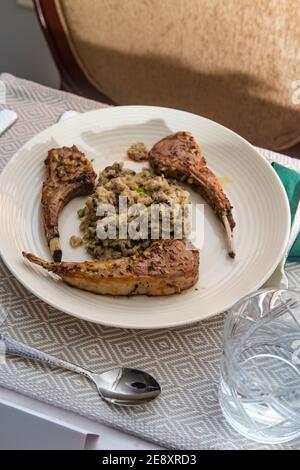 Côtes d'agneau marinées et risotto aux champignons Banque D'Images