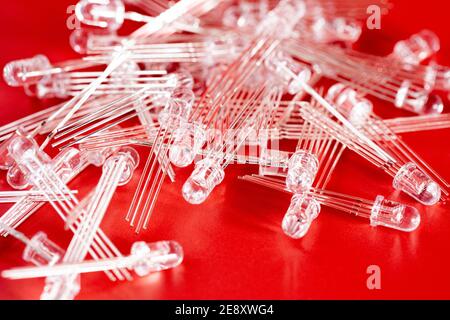 Pile de diodes LED blanches sur fond rouge. Composants électroniques et pièce de rechange Banque D'Images