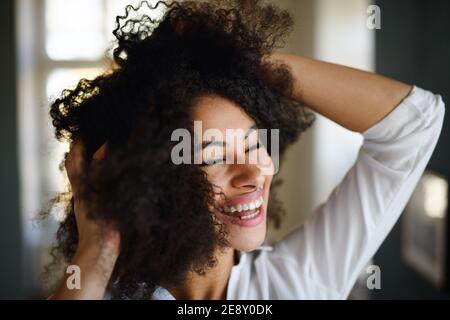 Portrait en gros plan de la jeune femme à l'intérieur, se sentant excitée. Banque D'Images