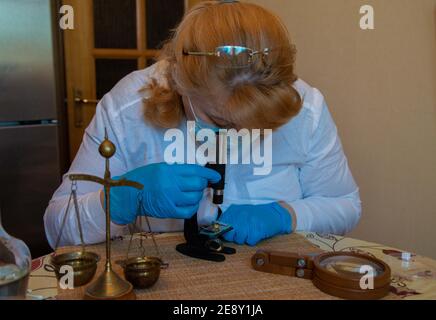 Microscope et mains en laboratoire bleu porter des gants 2021 Banque D'Images