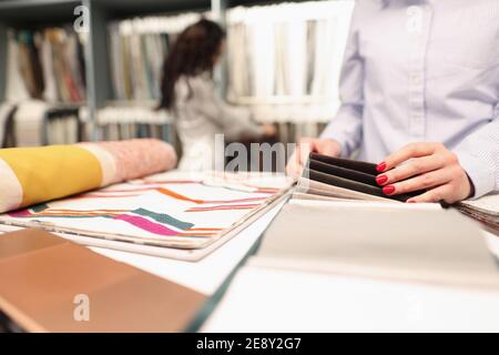 Une cabas choisit un échantillon de tissu de rideau dans un magasin fermé Banque D'Images