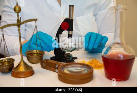 Microscope et mains en laboratoire bleu porter des gants 2021 Banque D'Images