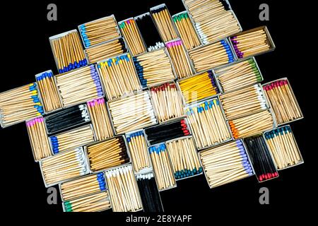 des bâtons de match multicolores dans des boîtes sur fond noir Banque D'Images