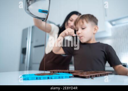 bonne mère et enfant de faire des bonbons au chocolat et de s'amuser à la cuisine maison Banque D'Images