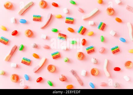 Fond de bonbons gélifiés aux couleurs de l'arc-en-ciel juteux. Motif de bonbons gélifiés sur fond rose Banque D'Images