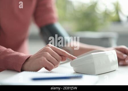Femme mesurant la pression artérielle avec le tonomètre électronique de gros plan Banque D'Images