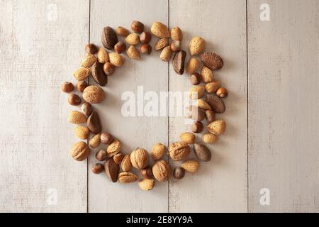 Amandes Shelles, noix, noix de macadamia, pacanes, noisettes disposées en cercle sur fond de bois Banque D'Images