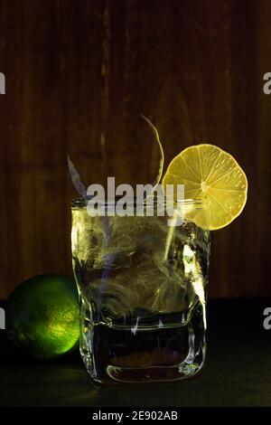 Décoration de cocktail verte avec citron vert. Cocktail encore vie avec fond en bois Banque D'Images