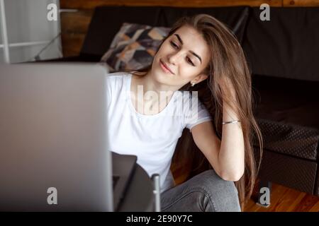 Jolie fille étudiante regarder le webinaire, écouter le cours en ligne, communiquer par conférence vidéo e-learn, étudier avec l'enseignant de leçon regarder dans l'ordinateur portable au cdm Banque D'Images