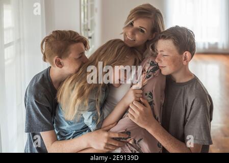 Portrait de famille de la belle famille avec des cheveux rouges embrassant studio Banque D'Images