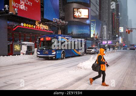 Un homme avec une caméra traverse devant le trafic venant en sens inverse dans Times Square pendant la tempête du 01 février 2021 à New York. La première fête de Pâques de 2021 a frappé des zones de la côte nord et centrale est, y compris la ville de New York, avec plus d'un pied de neige. Les transports en commun ont été réduits et les sites de vaccination contre le coronavirus ont été fermés, ce qui pourrait être la plus importante vague de tempête depuis le grand orage Sandy en 2012. (Photo de John Lamparski?SIPA USA) crédit: SIPA USA/Alay Live News Banque D'Images