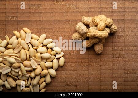 vue de dessus image de graines d'arachides pelées et non pelées et sur la table de coupe de bambou. (arachis hypogaea) graines comestibles. Concept de nutrition saine d'en-cas Banque D'Images