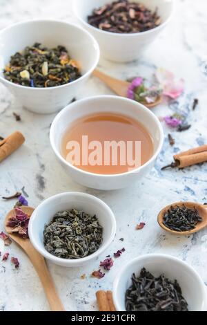 Tasse de thé et bols avec feuilles sèches sur la table Banque D'Images