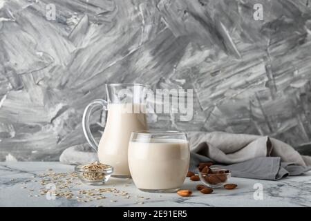 Pichet et verre de lait végétalien différent sur fond de couleur Banque D'Images
