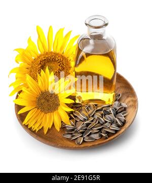 Bouteille d'huile, de graines et de tournesol dans une assiette sur fond blanc Banque D'Images