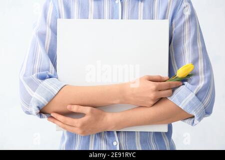 Jeune femme avec fleur de tulipe et tableau vide sur fond blanc, gros plan Banque D'Images