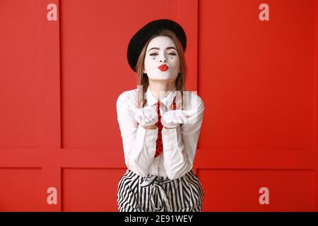 Pantomimiste femelle soufflant baiser sur fond de couleur Banque D'Images