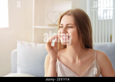 Belle jeune femme prenant des pilules à la maison Banque D'Images