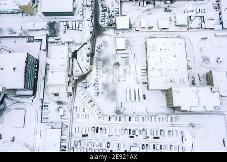 vue aérienne du dessus des toits enneigés des bâtiments industriels et entrepôts en hiver Banque D'Images